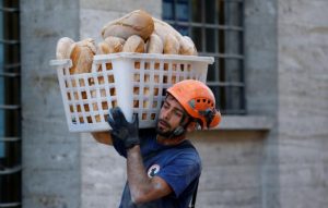 A rescuer carries bread following the earthquake in Amatrice, central Italy. REUTERS/Stefano Rellandini